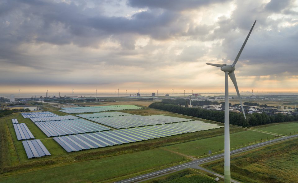 Birdview van energiepark met windmolens en zonnepanelen.