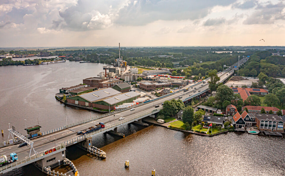 Luchtfoto van waterstofnetwerk bij industrieterrein aan het water in Zaanstad.