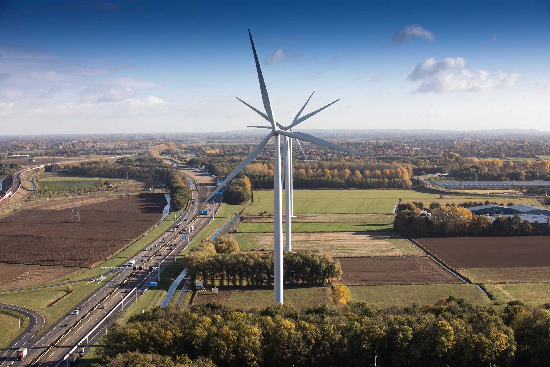 Luchtfoto van drie windmolens naast de A15 Nijmegen-Betuwe aangelegd door Firan.