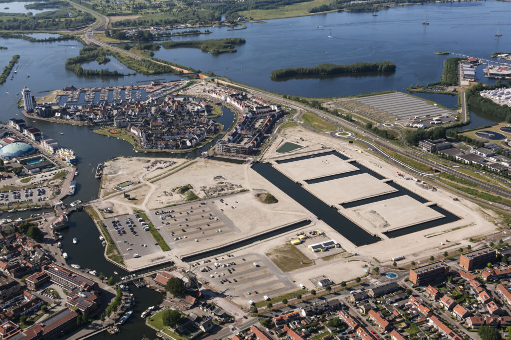 Luchtfoto van waterfront waar oprichting warmtenet voor nieuwbouwwijk Harwderwijk bezig is.